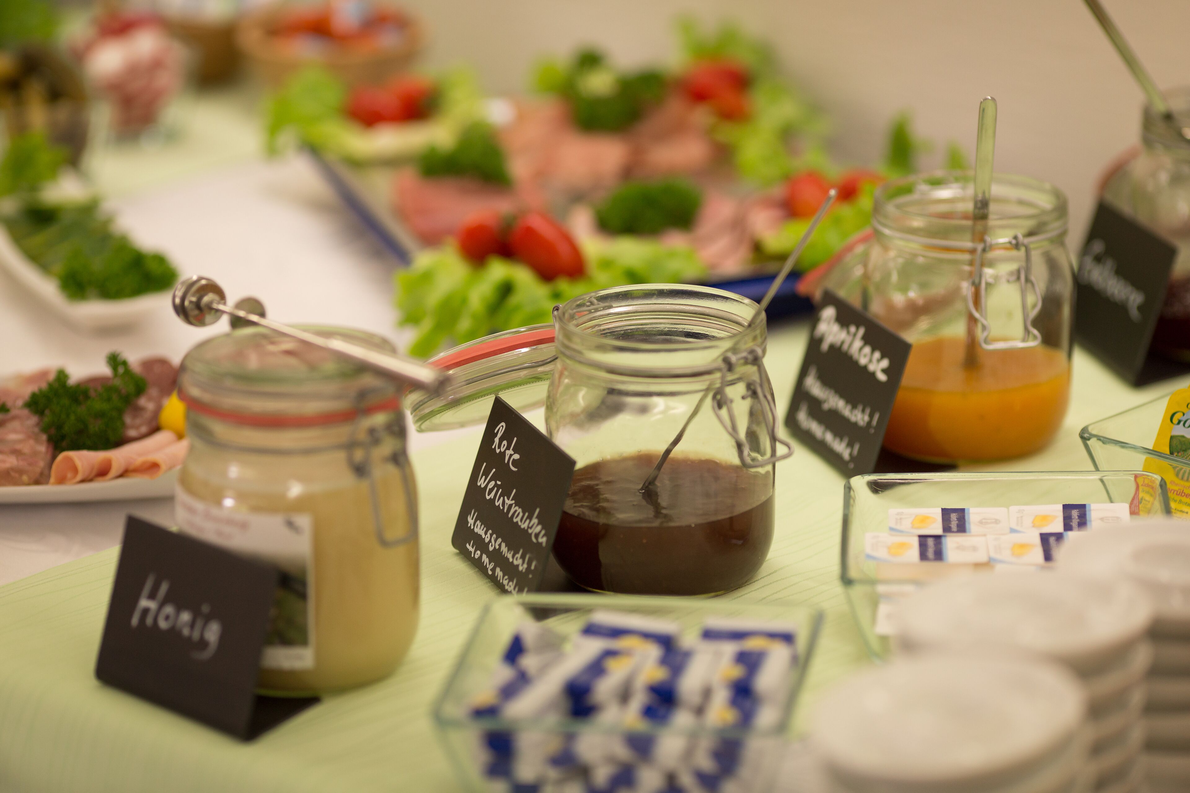 A buffet table with various food items and condiments.