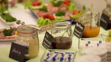 A buffet table with various food items and condiments.