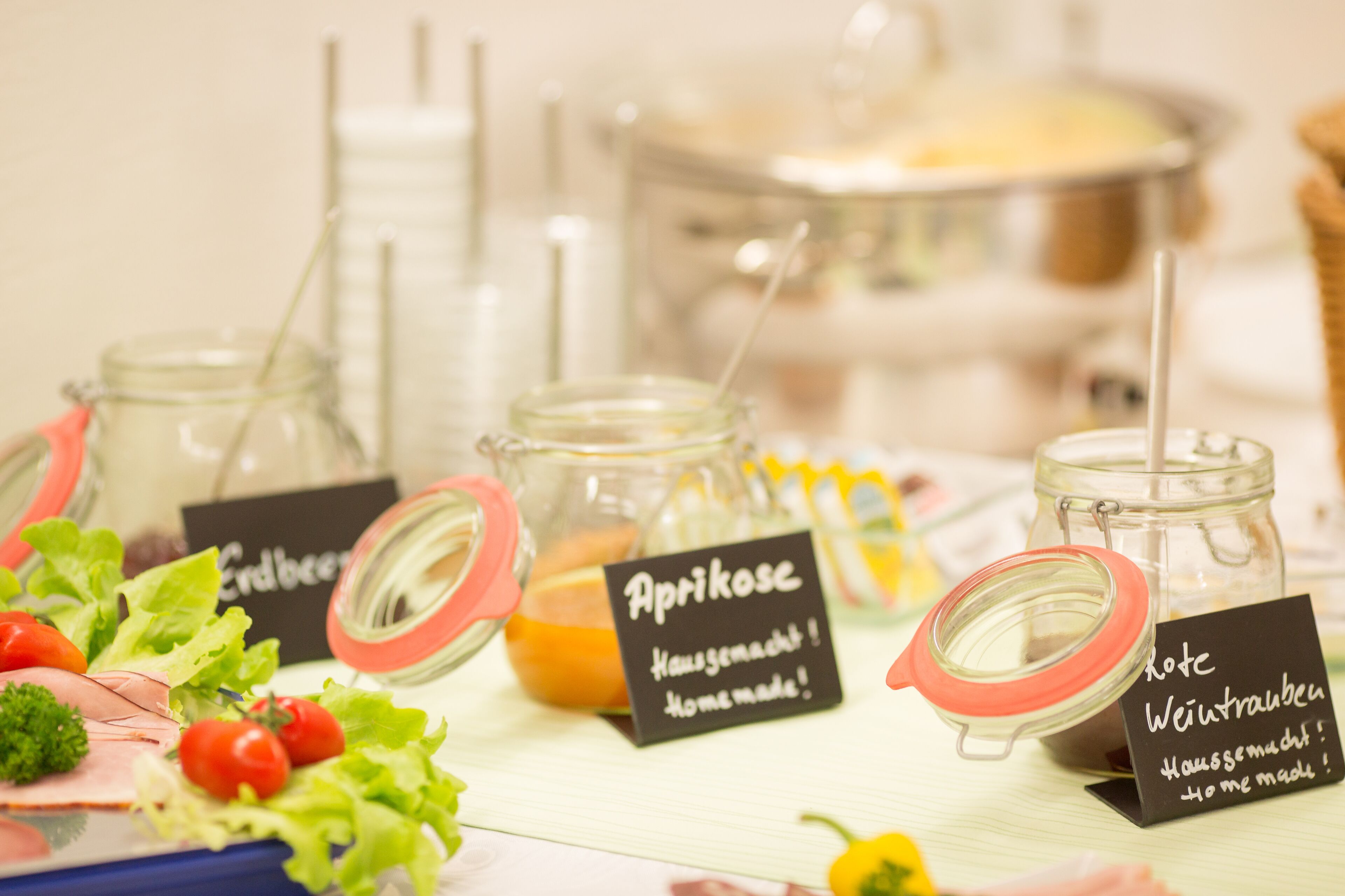 Una mesa de buffet con diferentes alimentos y frascos etiquetados de salsas.