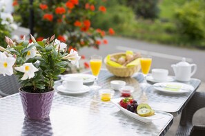 Une table de petit-déjeuner avec une plante en pot, des fruits et divers aliments pour le petit-déjeuner.