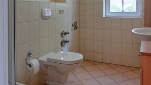 Kylpyhuone, jossa on wc, bidee ja ikkuna.