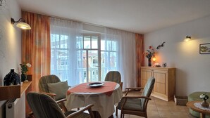 Ein Essbereich mit Tisch, Stühlen und einem Schrank.