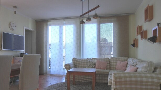Una sala de estar con sofá, mesa de centro y televisor.