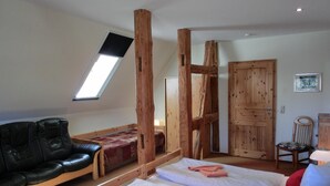 Una habitación con cama tipo litera, un sofá y una escalera de madera.