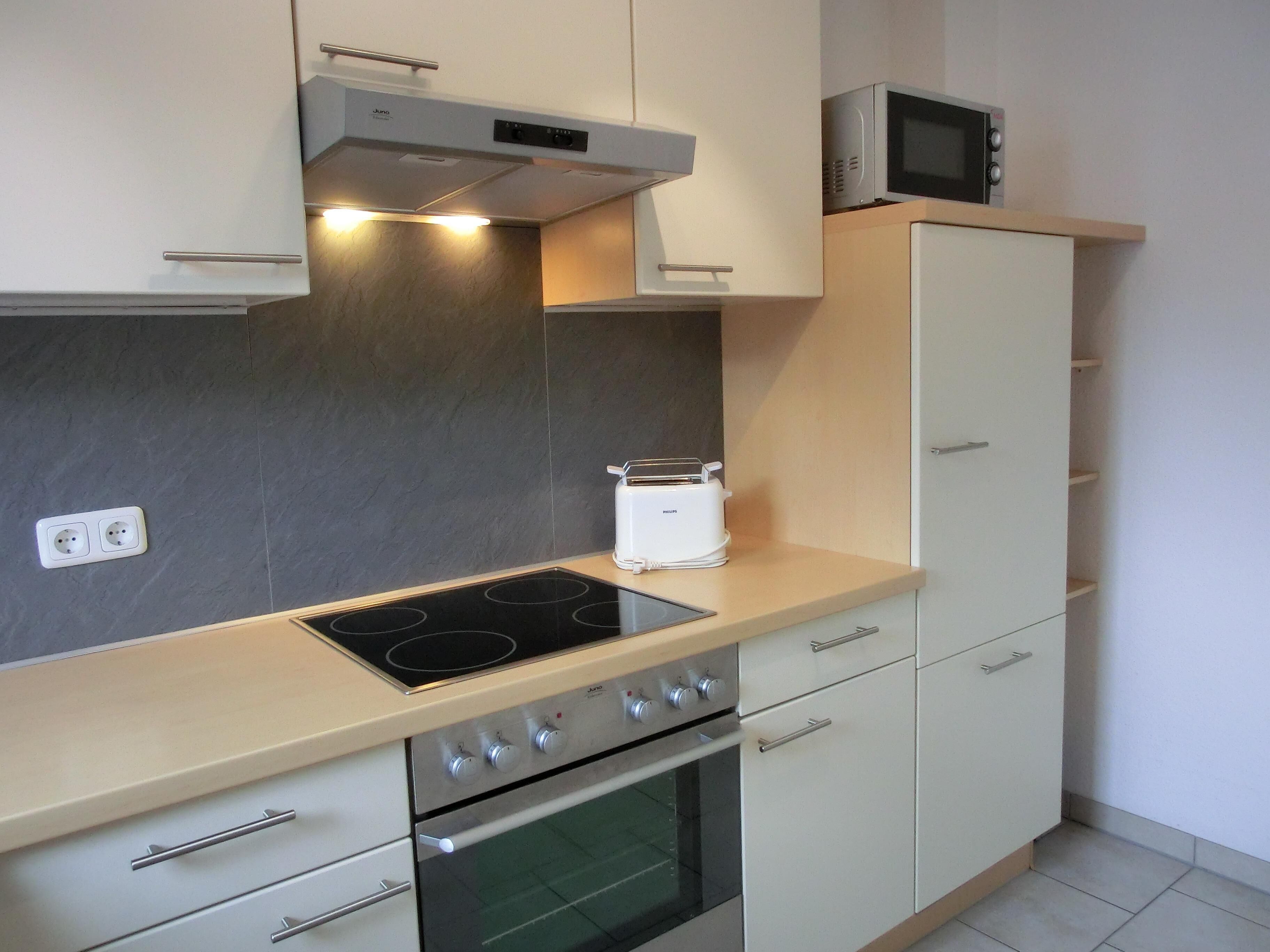 A modern kitchen with a built-in stove, oven, microwave, and toaster.