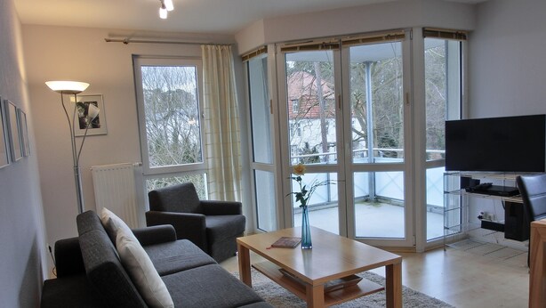 A modern living room with a sofa, armchairs, a coffee table, and a TV. - Strandnahe 2- Zi.-fewo für 3 Personen im 2. OG, mit Wlan (Graal-Müritz)