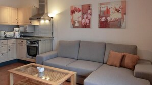 Een moderne keuken met een grijze bank en een salontafel.