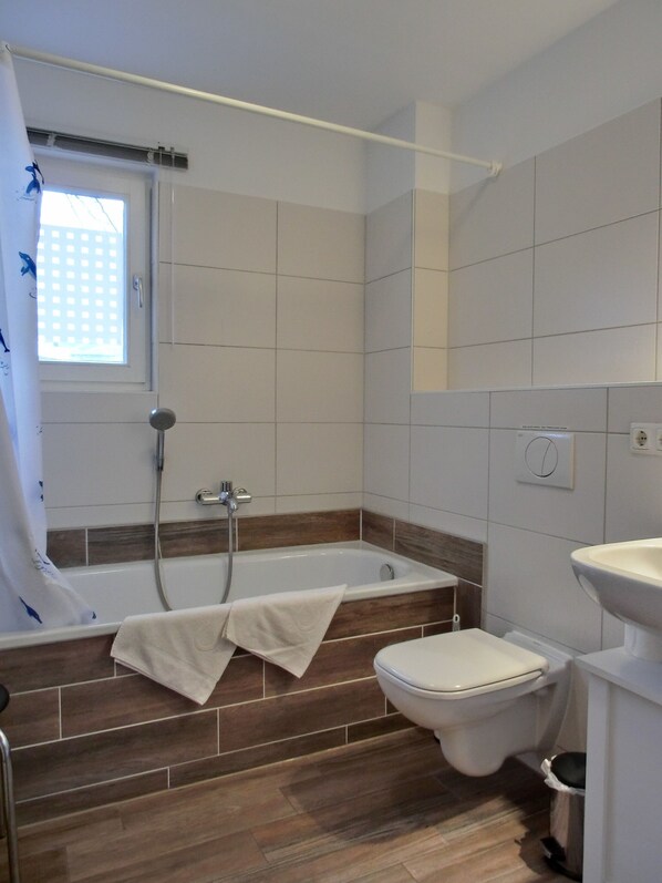 Une salle de bain avec une baignoire, des toilettes et un lavabo.