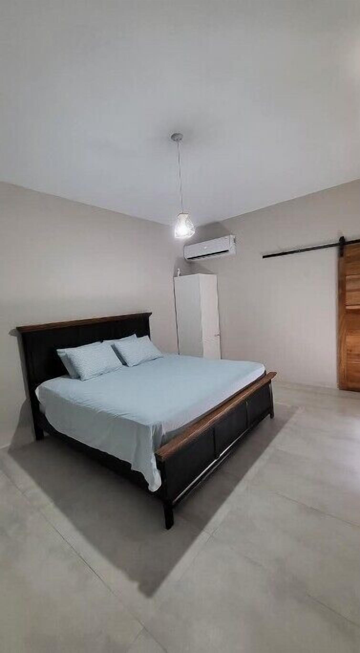 Ein Schlafzimmer mit einem Bett, einer Klimaanlage und einem Kleiderschrank.