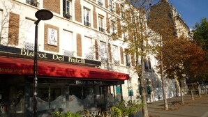 Ravintola nimeltä ’Bistro Del Fratelli’, jossa on ulkoterasseja ja punainen markiisi.