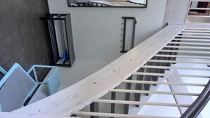 Een trap met metalen leuning en handrailing, die leidt naar een plateau met een spiegel en een radiator.