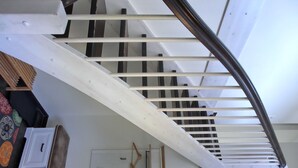 Eine Treppe mit weißen Geländern und einem Metallhandlauf.