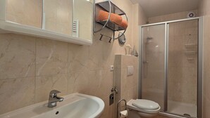 Ein Badezimmer mit Waschbecken, Toilette und Dusche.