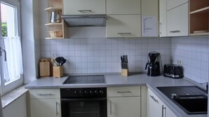 A kitchen with a stove, oven, sink, and various utensils. - 2-zi-fewo für 4 Pers. mit Wlan, Haustiere Erlaubt (Graal-Müritz)