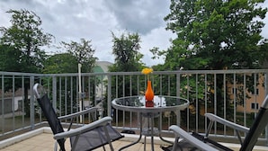 A balcony with a round glass table, two chairs, and a yellow flower vase. - 2-zimmer-fewo für 3 Pers. Inkl. Strandkorb (Graal-Müritz)