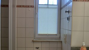 Een badkamer met toilet, wastafel en raam.