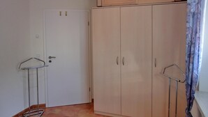 Una habitación con armario, puerta y un tendedero metálico.