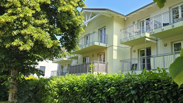 A multi-story residential building with balconies, surrounded by lush greenery. - Ruhige, Strandnahe 2-zimmer-ferienwohnung für 2 Pers. mit Balkon (Graal-Müritz)