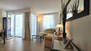 Ein modernes Wohnzimmer mit Essbereich, großen Fenstern und Blick ins Freie.