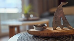 A wooden table with a metal sculpture of a bear and a small bowl on it. - 2-zi.-fewo im 2. OG, ca. 45 m² für 4 Personen mit Wlan (Graal-Müritz)