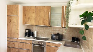 Eine Küche mit Holzausstattung, einer Mikrowelle, einem Toaster und einer Kaffeemaschine.