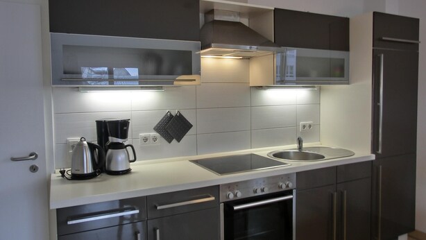 A modern kitchen with stainless steel appliances, a built-in oven, and a microwave.