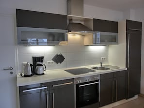 Una cocina moderna con electrodomésticos de acero inoxidable, horno integrado y microondas.