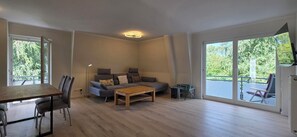 A spacious living area with a sofa, coffee table, and dining table.