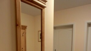 A hallway with a large mirror, a door, and a small framed picture on the wall. - 3-room apartment on the first floor, suitable for 6 people. (Graal-Müritz)