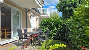 A patio with a table and chairs, a door, and a balcony. - 3-room apartment on the first floor, suitable for 6 people. (Graal-Müritz)