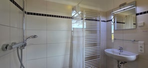 A bathroom with a shower, a sink, and a towel rack. - Doppelhaushälfte mit ca. 95 m² Wohnfläche für 8 Personen (Graal-Müritz)