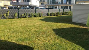 Ein Wohngebiet mit modernen Häusern, einem eingezäunten Garten und geparkten Autos.
