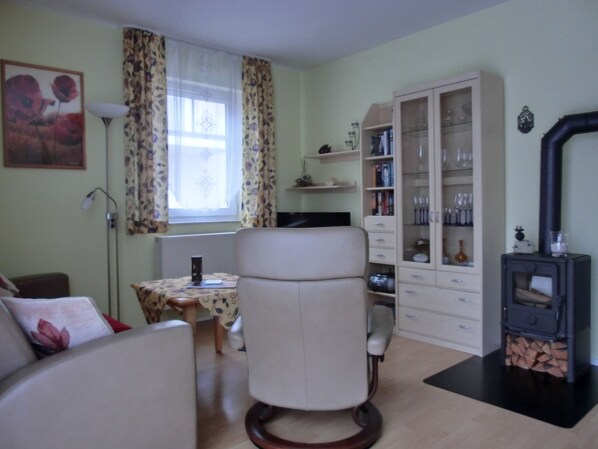 Un salon comprenant un canapé, un fauteuil, une table, un meuble et une cheminée.