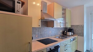 Una cocina moderna equipada con microondas, estufa y cafetera.