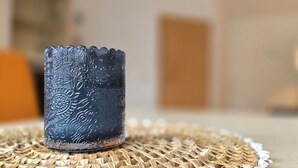 Un candelabro de vidrio azul sobre un posavasos tejido.