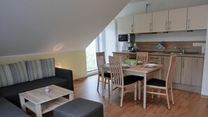 Un appartement moderne comprenant un coin repas, une cuisine et un espace de vie.