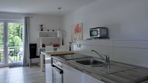 Una cocina moderna con una isla grande, electrodomésticos de acero inoxidable y vistas al exterior.
