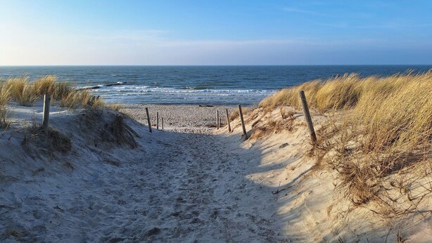A sandy beach path leading to the ocean with dunes and wooden posts. - Strandnahe 2-zi-wohnung im Obergeschoss mit Zwei Balkonen (Graal-Müritz)