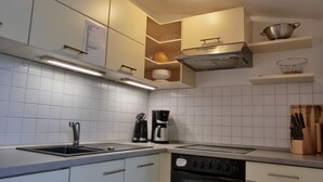 Una cocina moderna con baldosas blancas, electrodomésticos de acero inoxidable y horno empotrado.