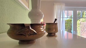 Une table sur laquelle sont posés deux récipients en métal, l’un plus grand que l’autre, dans une pièce dotée d’une fenêtre et d’un mur vert.