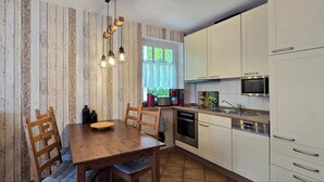 Una cocina con paredes de madera, una mesa de comedor de madera y electrodomésticos modernos.