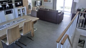 A modern apartment with a dining area, kitchen, living room, and a balcony. - 3- Zi.-fewo mit 2 Schlafzimmern auf 2 Etagen für 4 Pers. mit Wlan (Graal-Müritz)