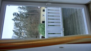 A skylight window with a white blind, a white ceiling, and a view of a white fence and trees outside. - 2-zimmer-ferienwohnung für 4 Personen im 1. Obergeschoss -mit Wlan (Neu Hirschburg)