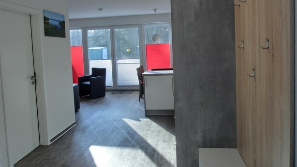 Ein moderner Büroraum mit Schreibtisch, Stuhl und Blick durch große Fenster.