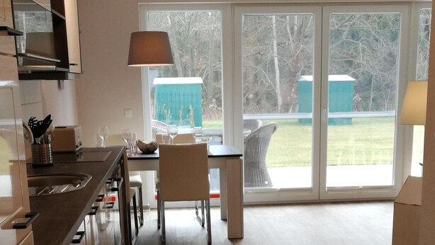 Una cocina moderna con comedor, ventanas amplias y vistas al exterior.