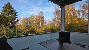 Un balcon donnant sur des arbres et un ciel dégagé.