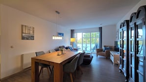Une cuisine moderne avec un coin repas, de grandes fenêtres et un espace salon confortable.