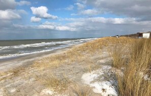 A beach with sand dunes and a small building in the distance. - 2-zimmer-fewo mit 1 SZ für 2 Pers. mit Wlan (Graal-Müritz)