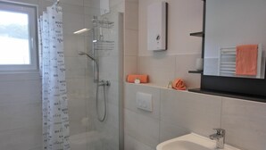 A modern bathroom with a shower, toilet, and sink. - 2-zimmer-fewo für 3 Pers. im OG mit Wlan (Graal-Müritz)