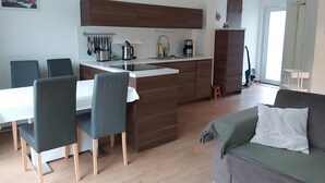 Eine moderne Küche mit einer zentralen Kochinsel, Holzschränken und einem Essbereich mit Stühlen.